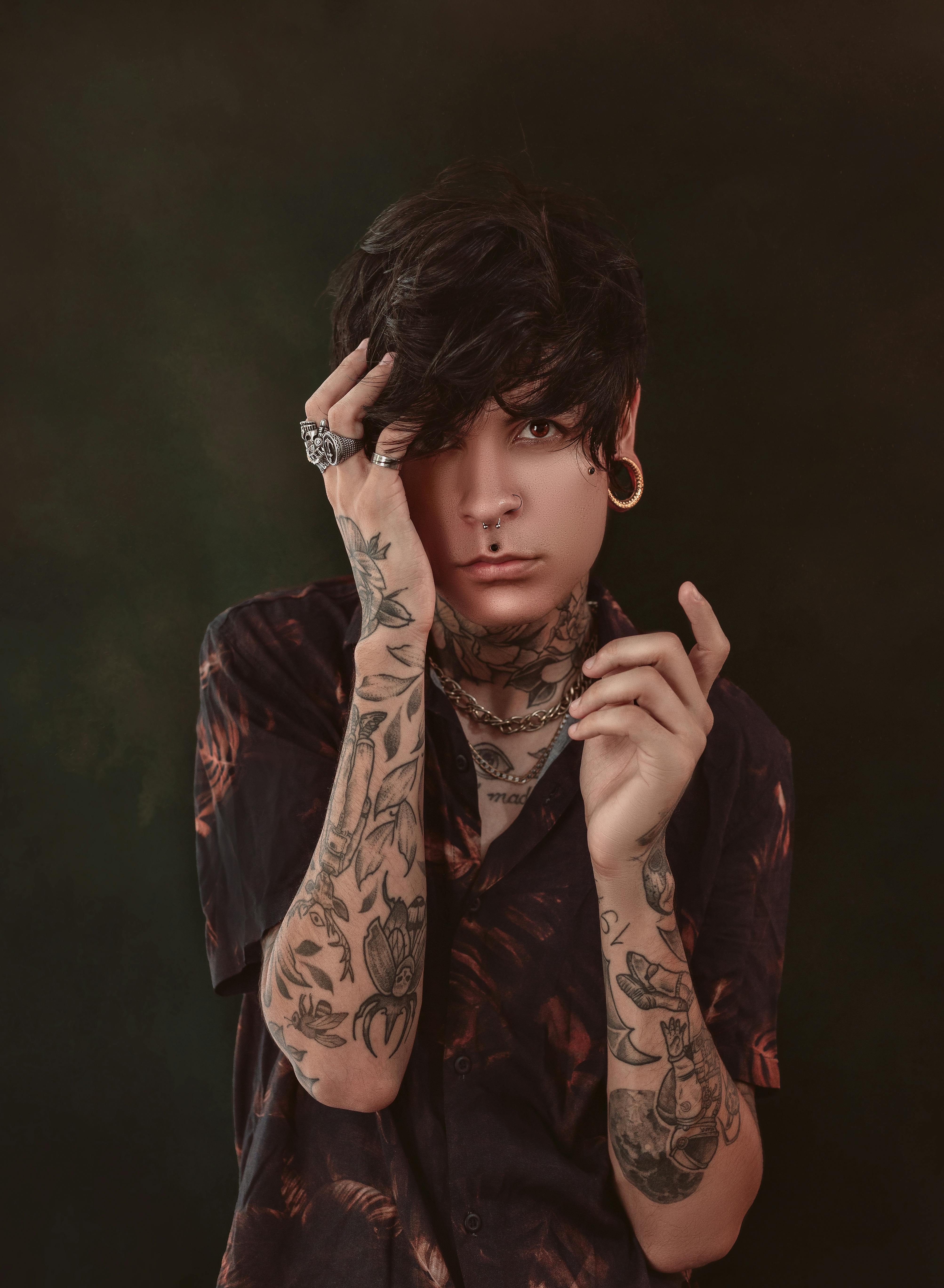 Androgynous male with tattoos and piercing · Free Stock Photo